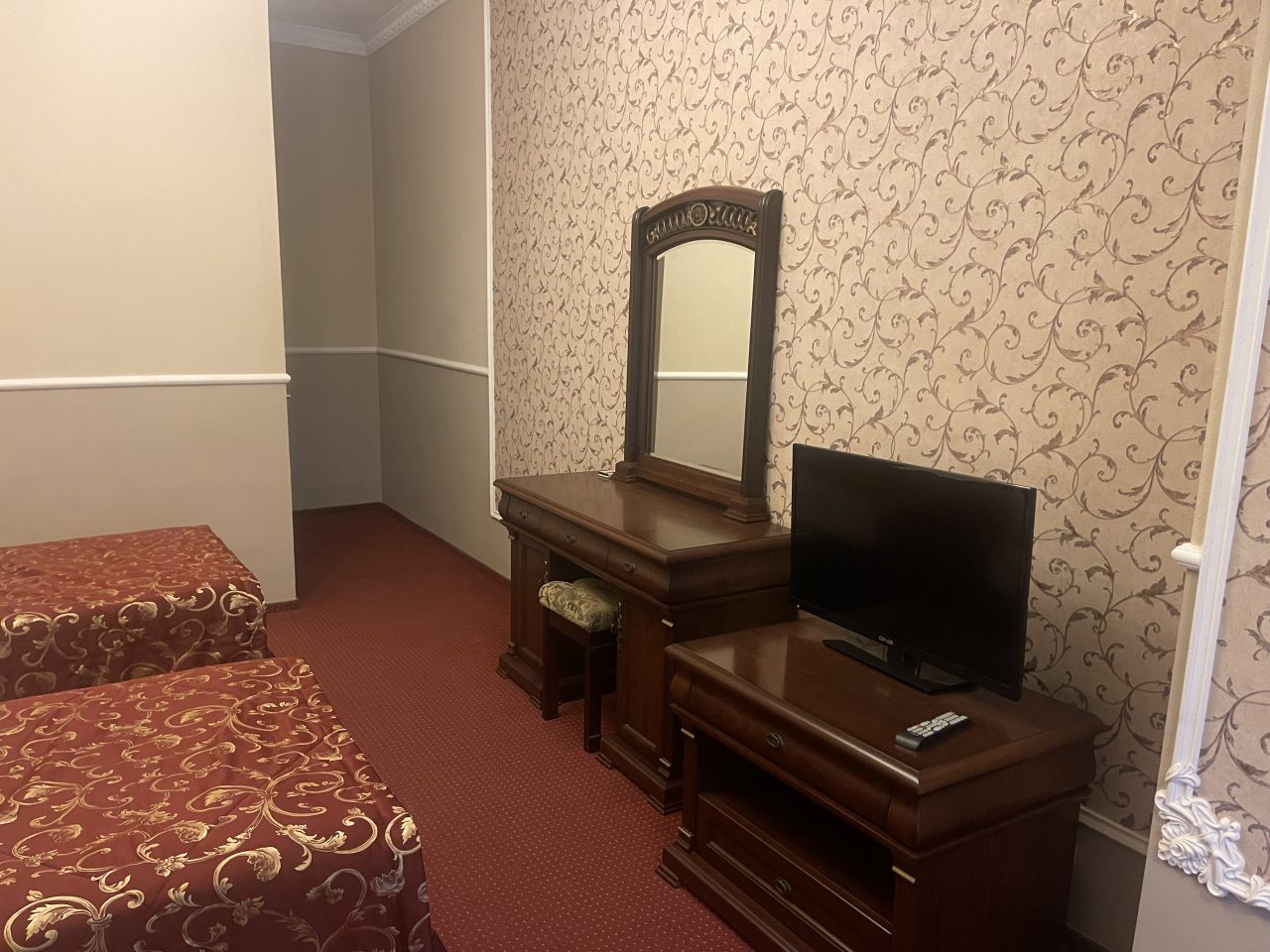 ТВ и комод в номере с двумя раздельными кроватями.