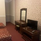 ТВ и комод в номере с двумя раздельными кроватями.