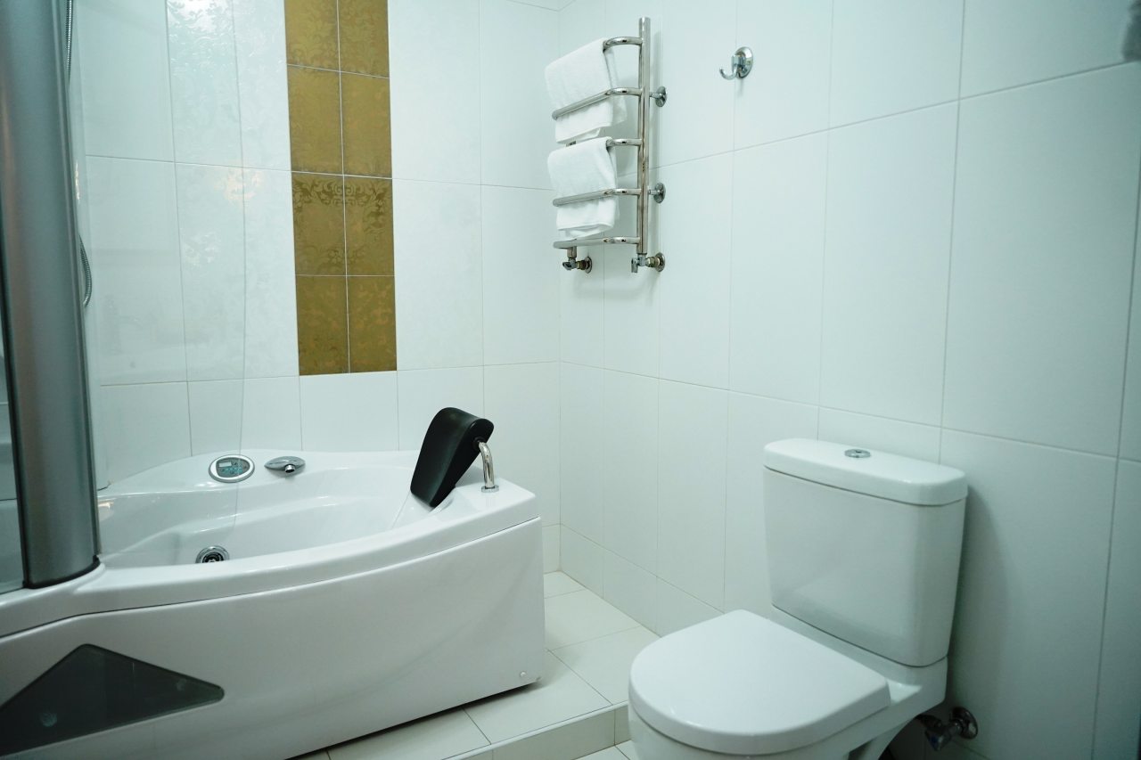 Ванная комната с ванной с гидромассажем в номере.