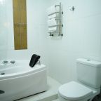 Ванная комната с ванной с гидромассажем в номере.