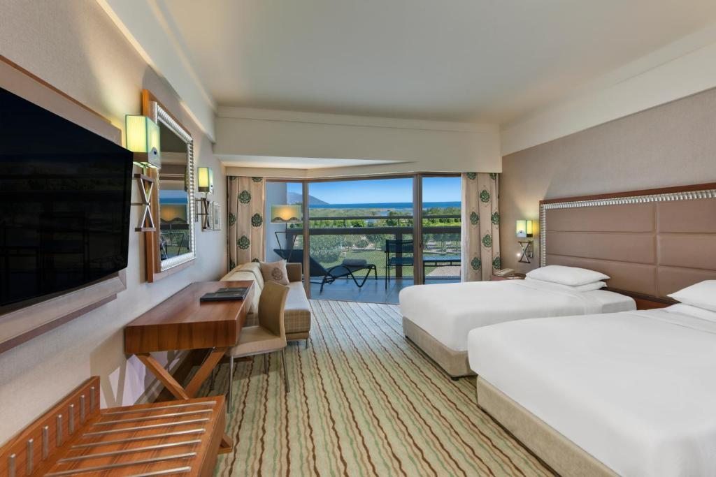 Трехместный (Двухместный номер с 2 отдельными кроватями и выходом к бассейну, вид на море) курортного отеля Hilton Dalaman Sarigerme, Даламан