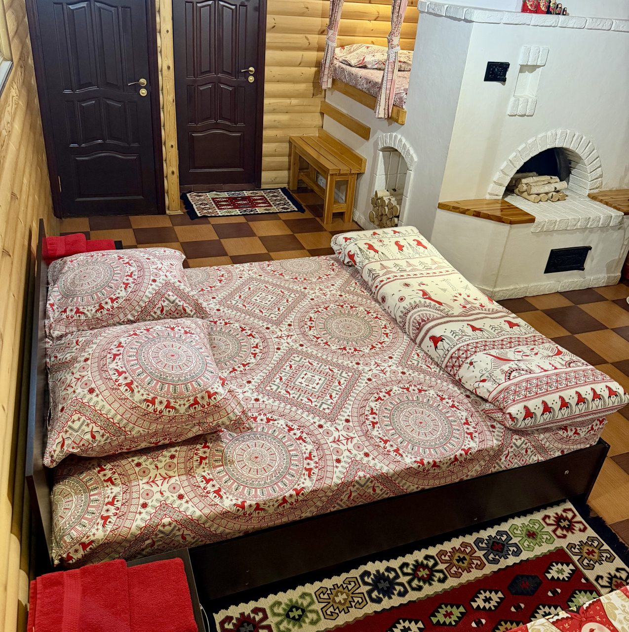 Двуспальная кровать и настоящая печка,на которой можно спать
