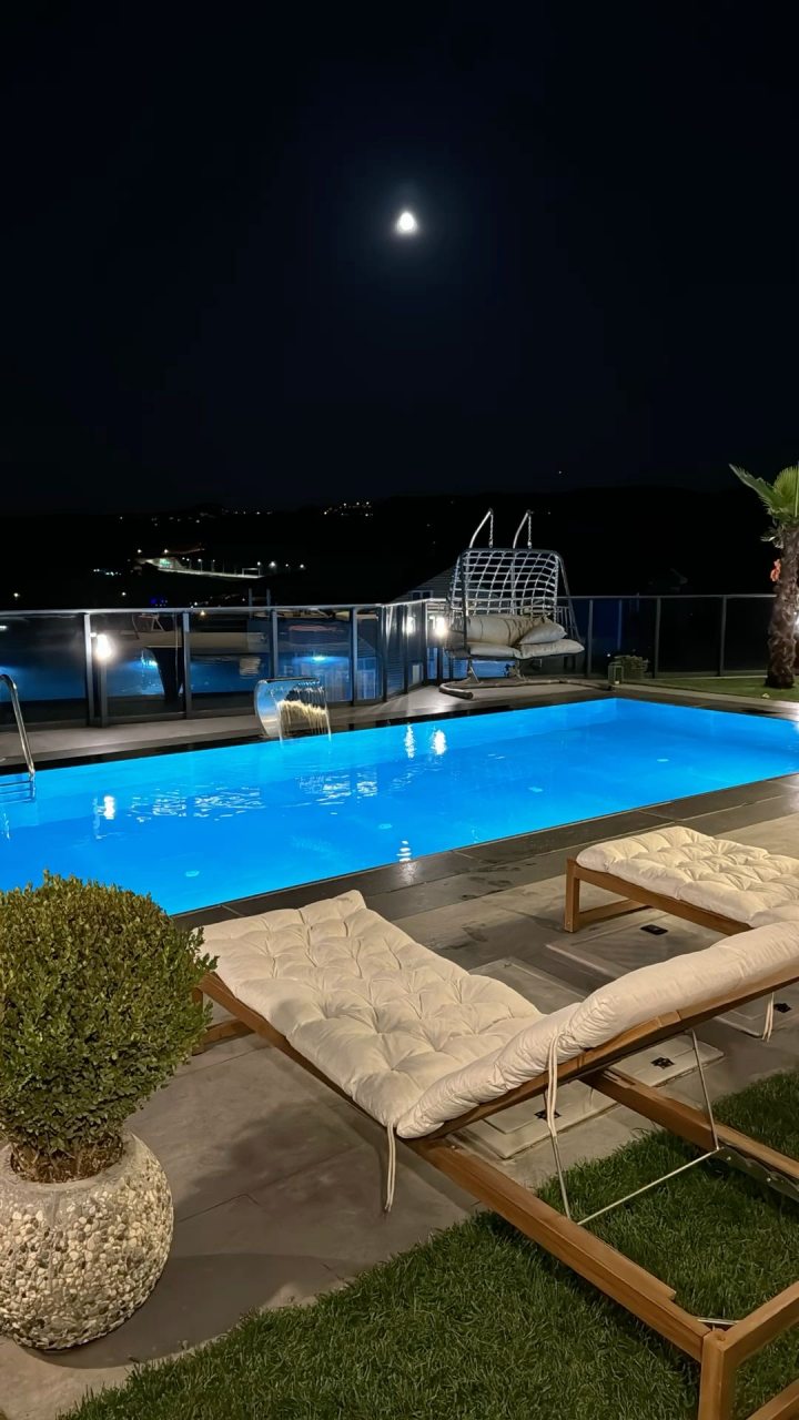 Подогреваемый бассейн на крыше здания с зоной отдыха и видом