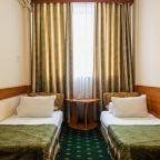 Светлый гостиничный номер с двумя кроватями.