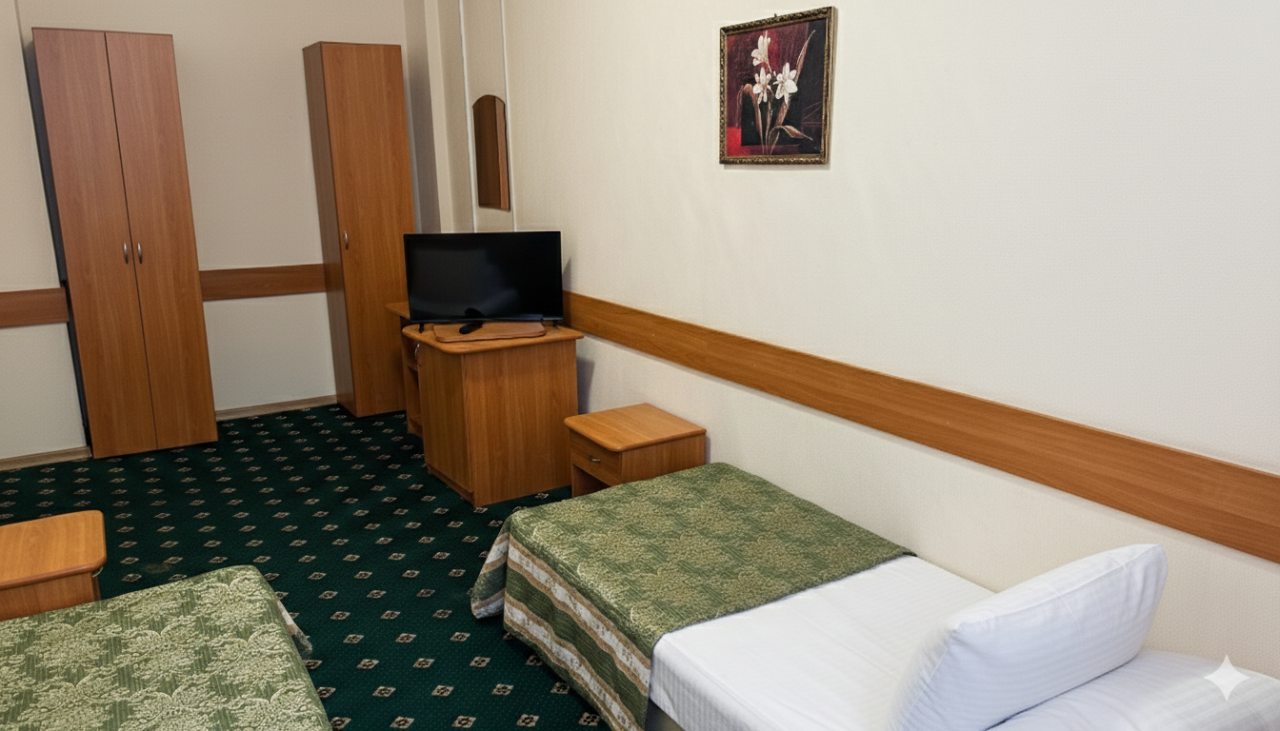 Уютный гостиничный номер с двумя кроватями и телевизором.