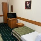 Уютный гостиничный номер с двумя кроватями и телевизором.