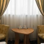 Интерьер номера с мягкими креслами и видом на город.