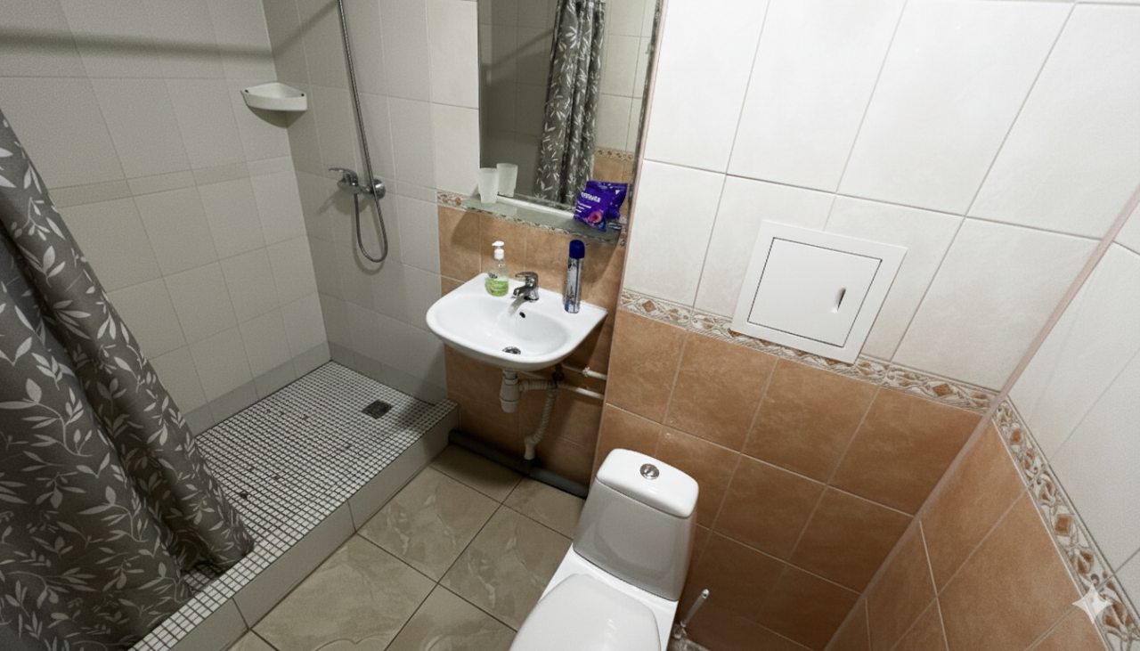 Светлая ванная комната с душевой кабиной, раковиной и ТЦ.