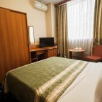 Уютный номер с большой кроватью и зеленым покрывалом.