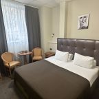 Уютный номер с большой кроватью и хородильником.