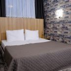 Гостиничный номер с картиной и темными шторами.