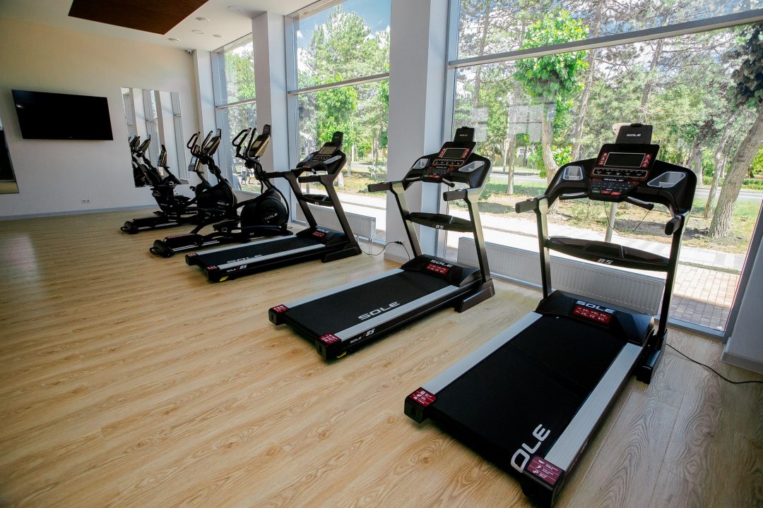 Просторный фитнес зал с современными кардио тренажерами и панорамным видам на Пионерский проспект