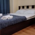 Удобная двуспальная кровать с постельным бельём из хлопка и полотенцами в семейном номере в гостевом доме 2step на Владимирском проспекте в центре Питера