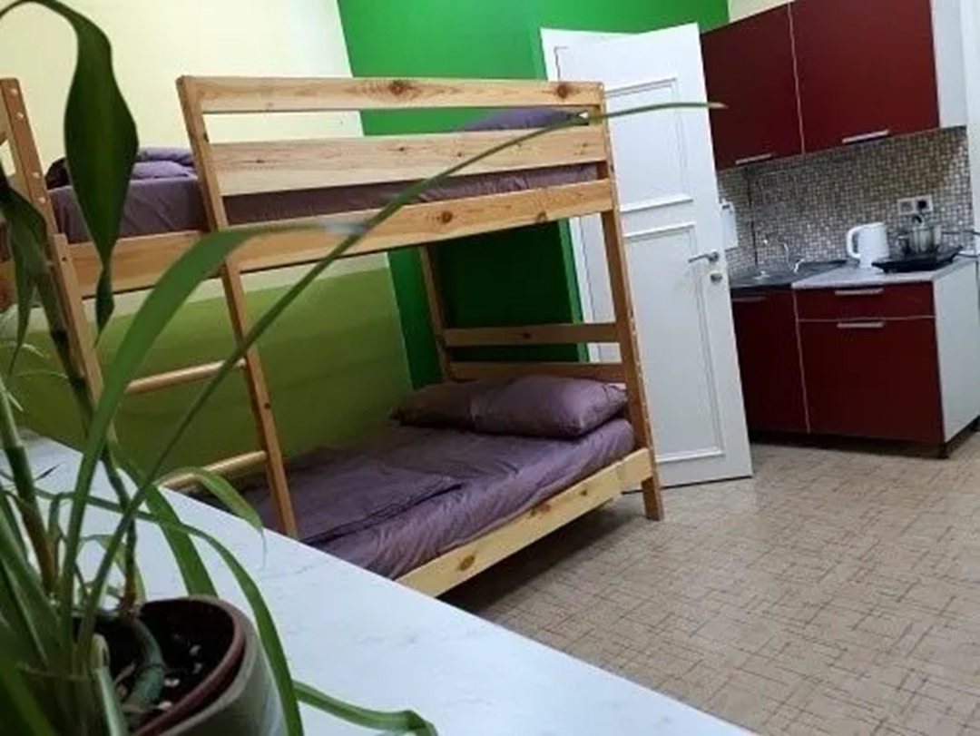 двухярусная двуспальная кровать, кухня, дверь в санузел.