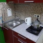 кухня с индукционной плиткой, раковиной и электрочайником.