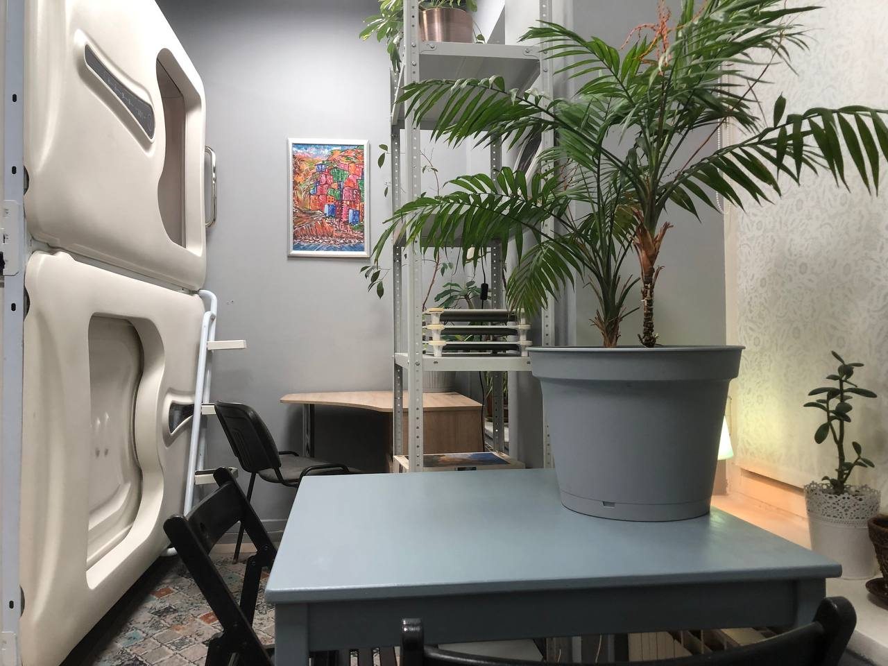 Уголок с односпальными капсулами, стеллаж и столы.