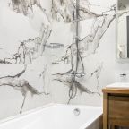 Уютная ванная с чистыми полотенцами и халатами для гостей