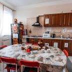 Кухня с плитой, чайником, СВ печью, посудой и уютным столом.