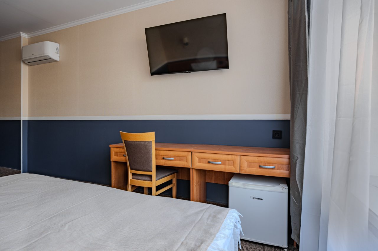 Номер с мягкой кроватью, телевизором и рабочей зоной со стол