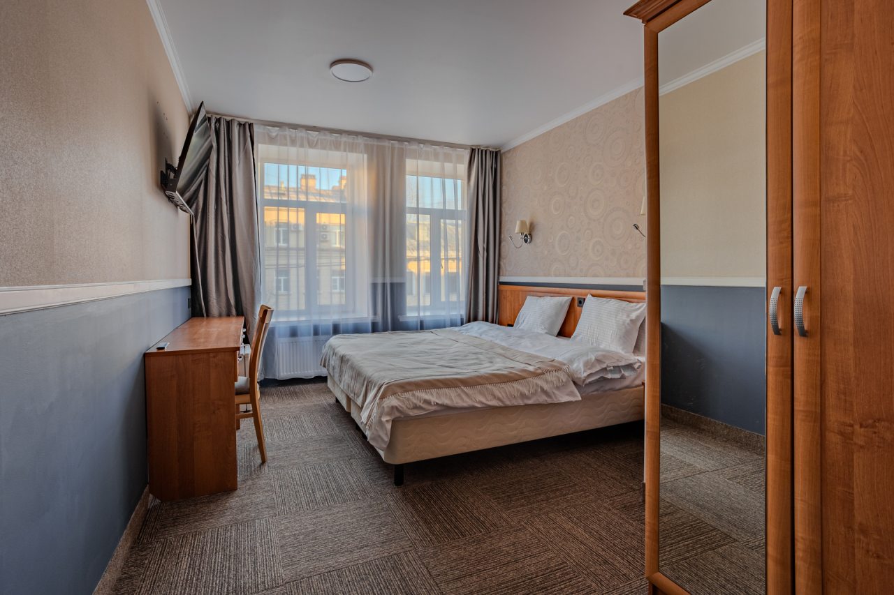 Светлый номер с удобной кроватью, телевизором и столом для р