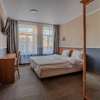 Светлый номер с удобной кроватью, телевизором и столом для р