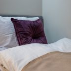 Приятный номер с кроватью, телевизором и небольшим столиком.