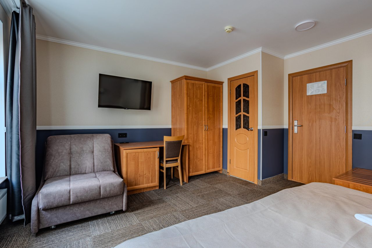 Светлый номер с удобной кроватью, телевизором и столом для р