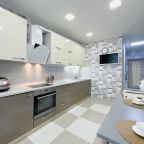 Современная кухня с техникой, светлыми фасадами и обеденной