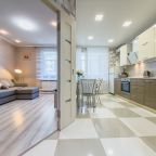 Уютная гостиная с диваном и видом в кухню. Светло, просторно