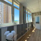 Светлая лоджия с видом на море и бытовым помещением