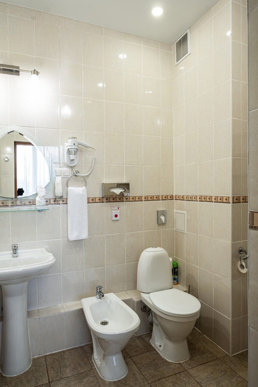 В ванной косметические принадлежности, халат, тапочки,фен.