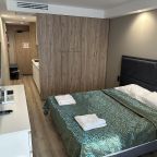 Двуспальная кровать и телевизор с плоским экраном