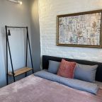 Спальня с кроватью, телевизором и вешалом для одежды