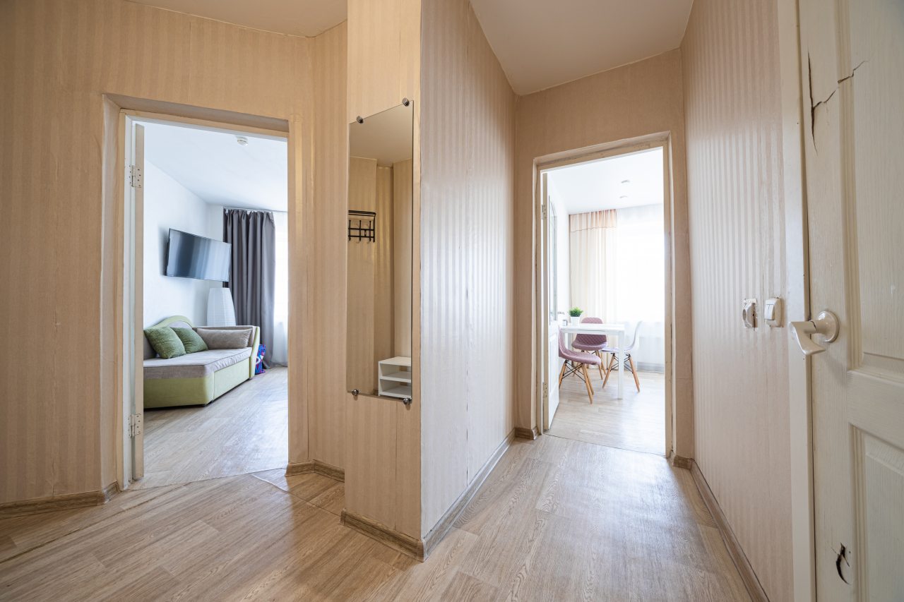 она у входа с вешалкой, обувницей и зеркалом для удобства.