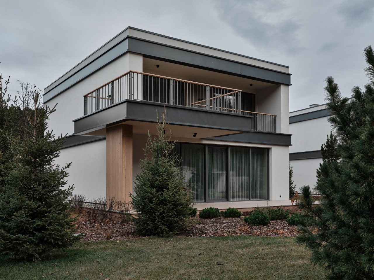 Двухэтажный дом в отдалении с видом на сад и горы.