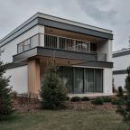 Двухэтажный дом в отдалении с видом на сад и горы.