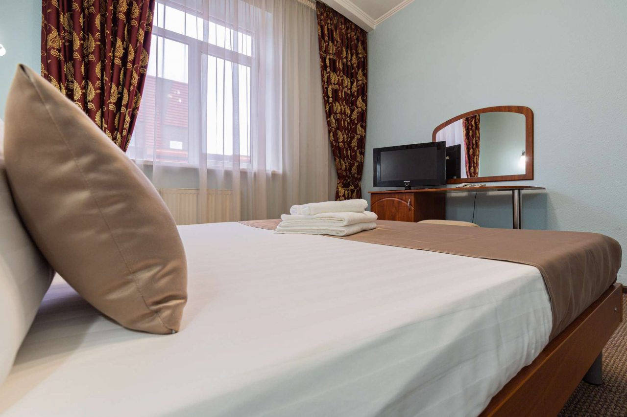 Окно с красными шторами и белыми занавесками.