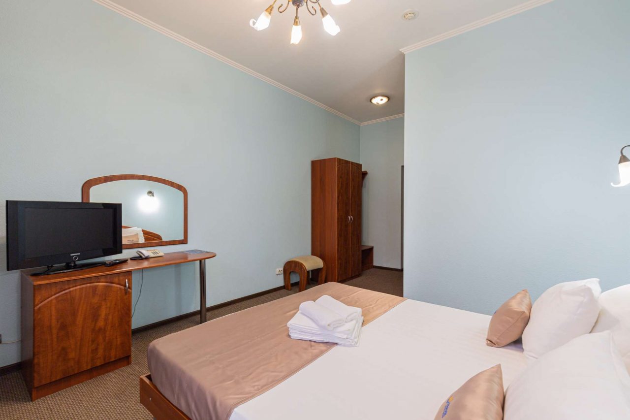 На кровати аккуратно уложены подушки и покрывало.