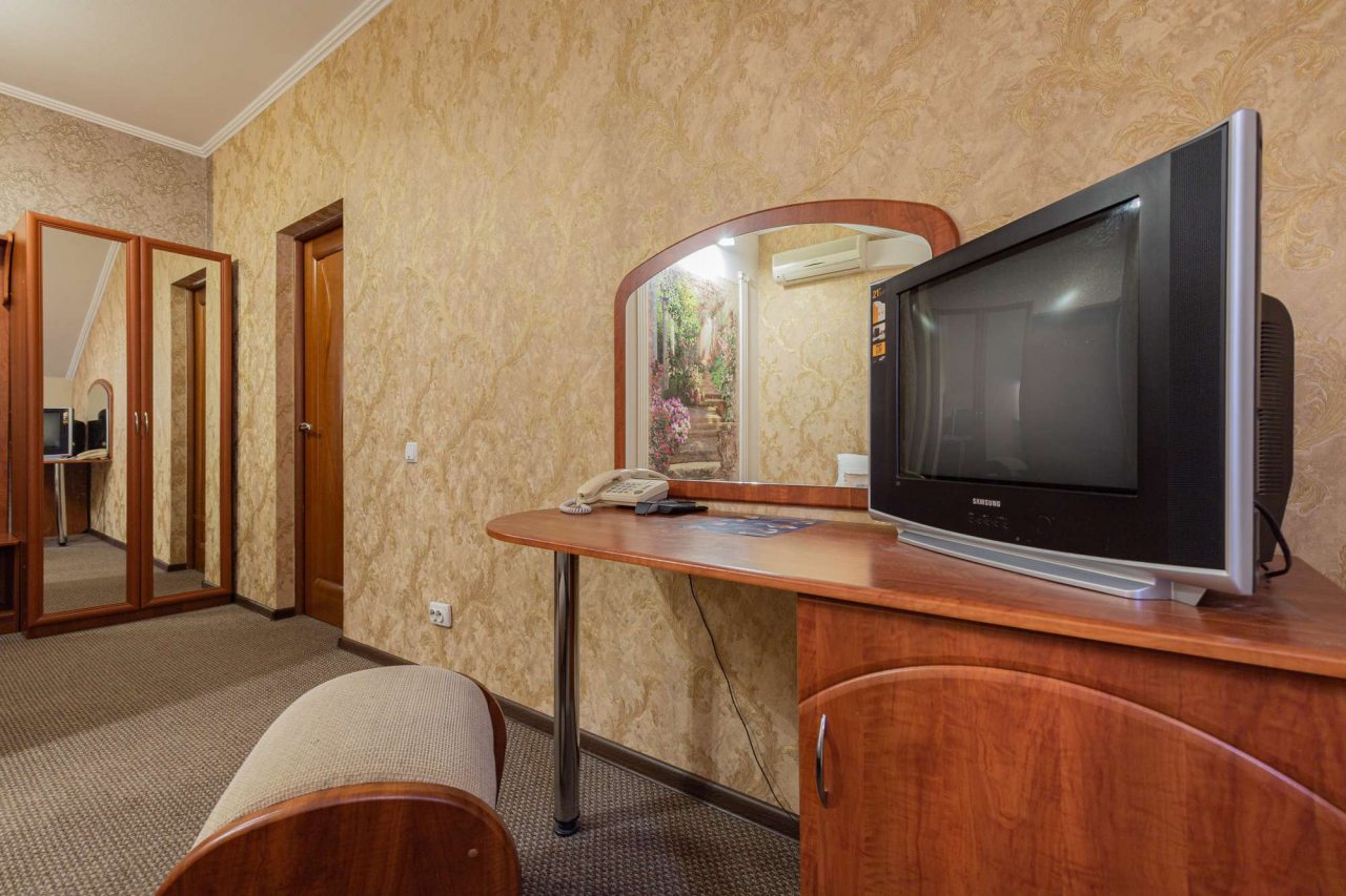 В комнате  есть телевизор на деревянной тумбе.