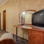 В комнате  есть телевизор на деревянной тумбе.