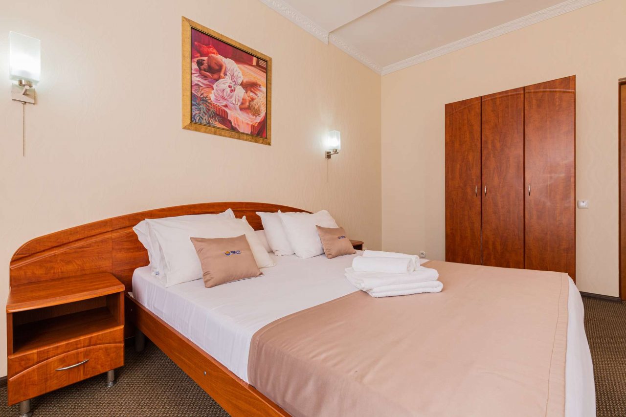 На кровати аккуратно сложены белые полотенца.