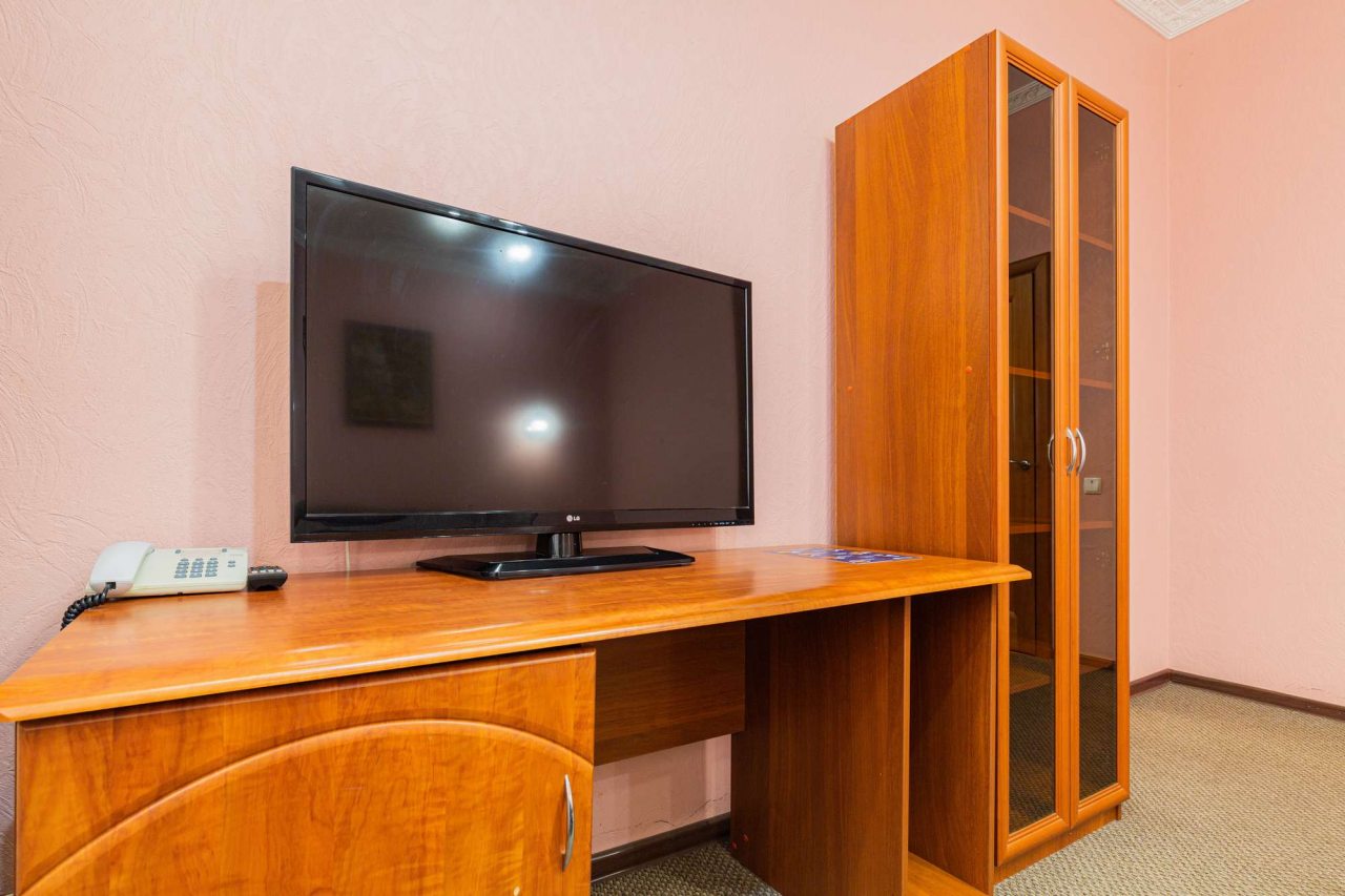 В комнате  есть телевизор на деревянном столе.