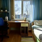 Спальная комната с одноместной кроватью и рабочей зоной.