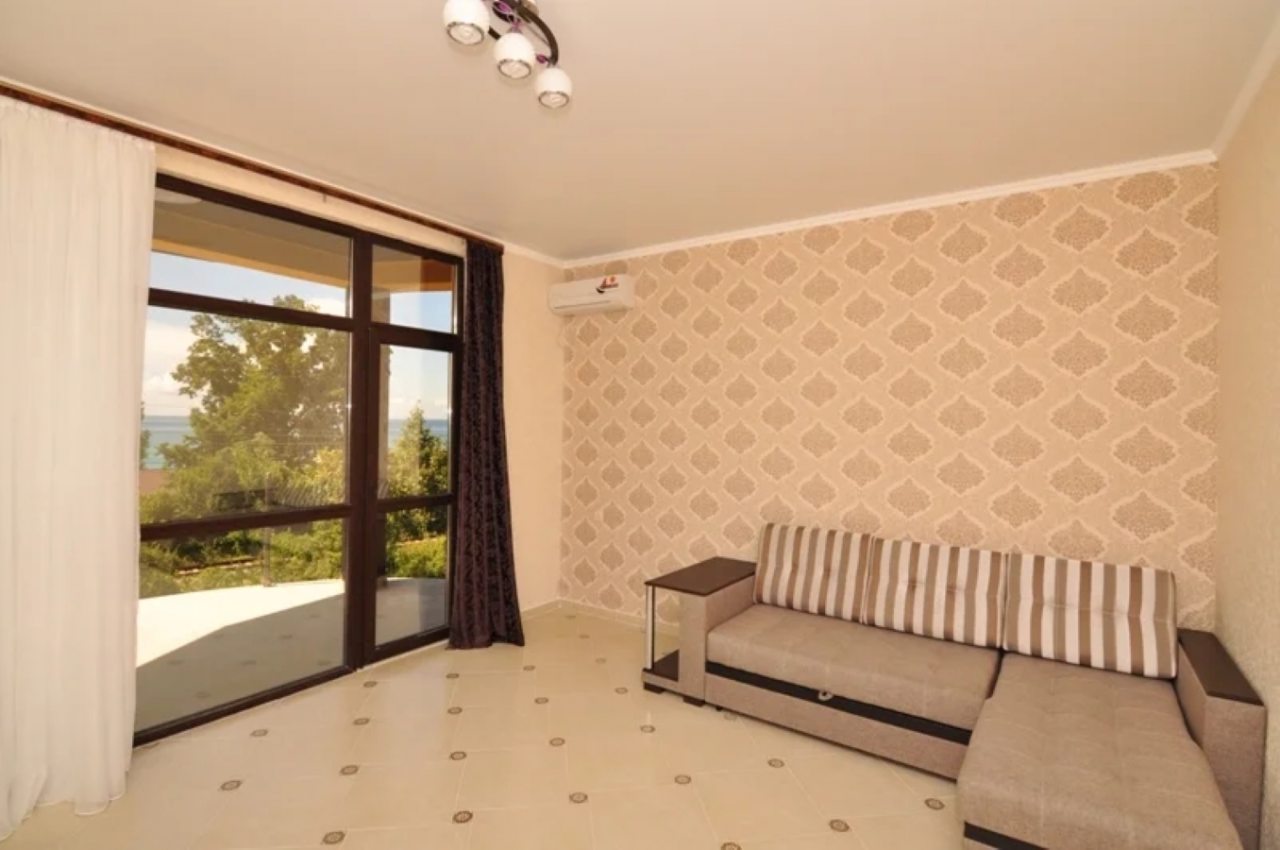 Гостиная зона с диваном и панорамными окнами