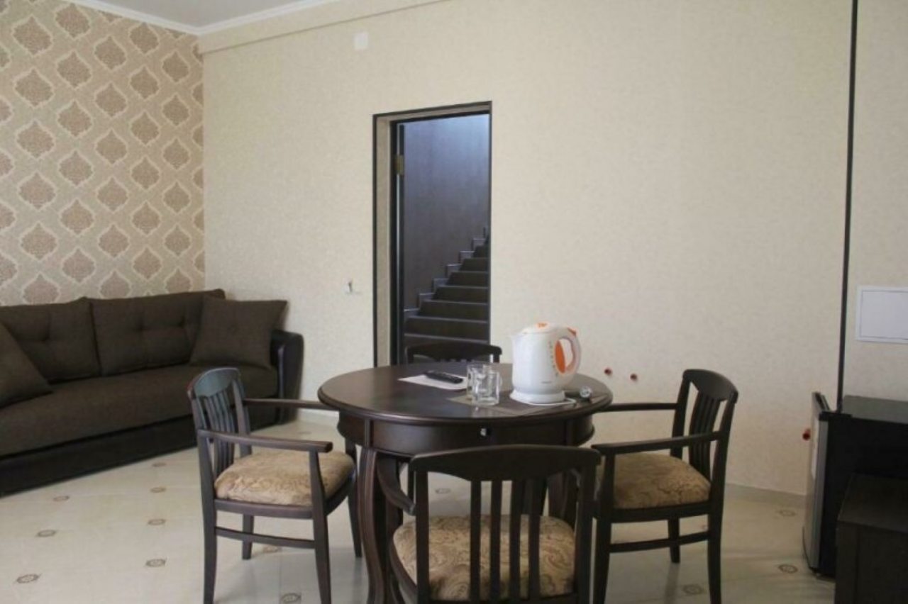 Обеденная зона с чайником, столом и мягким диваном