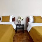 Спальня с двумя односпальными кроватями и большим окном с ви