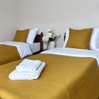 Спальня с двумя односпальными кроватями и большим окном с ви