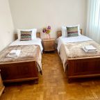 Спальня с двумя односпальными кроватями и большим окном с ви