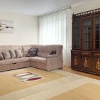 Зал с большим диваном и креслом.  Есть телевизор со SMART TV