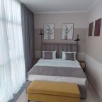 Двухспальная кровать, прикроватный пуф,панорамные окна.